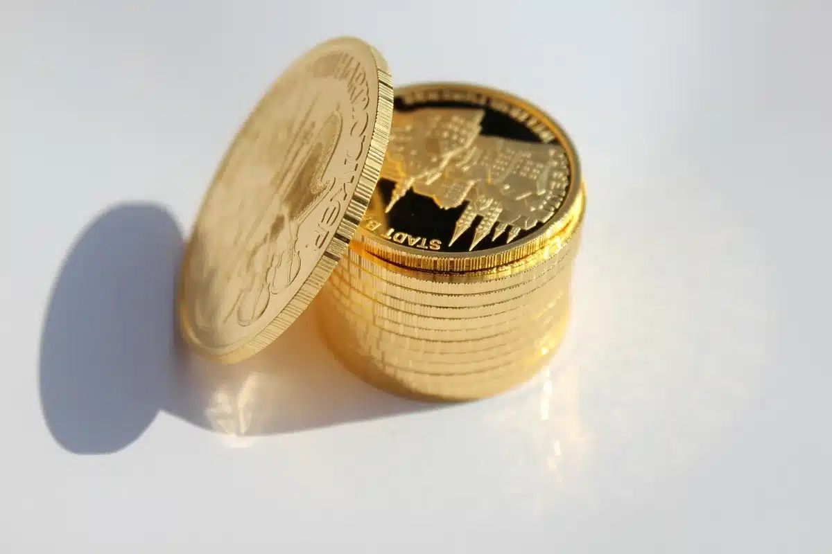 Close-up of an unbranded collector coin in a protective case on a wooden table, a soft out-of-focus wallet and faint banknotes in background