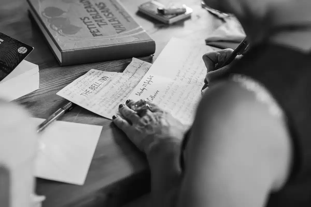 Neat desk with pension notice, a pair of reading glasses and a small stack of generic coins blurred in background, sunlight on the page