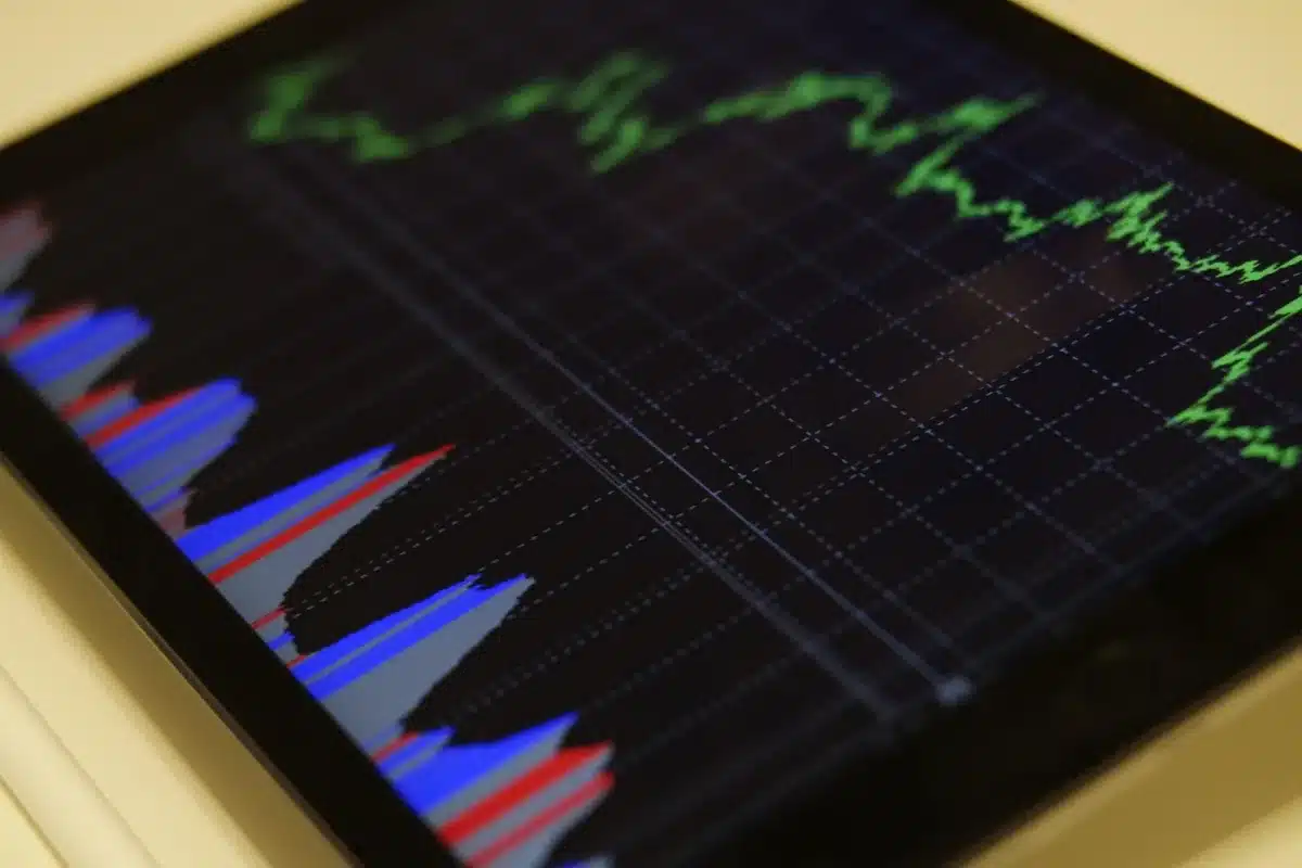 Close-up of a desktop with a printed forex chart, a hand pointing at a falling EUR/USD line on paper, a calculator and a notepad nearby