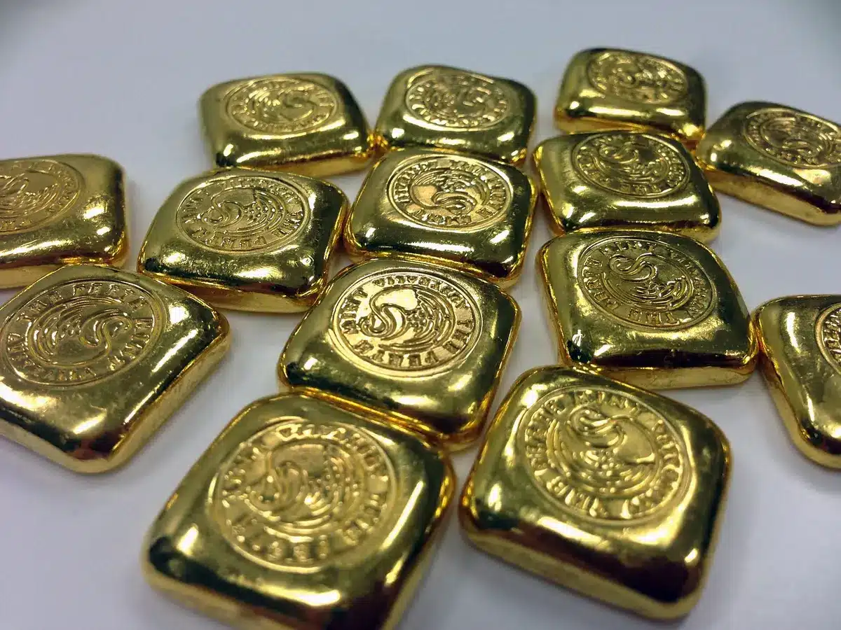 Vault of stacked generic gold bars in bright light, no logos or identifiable marks